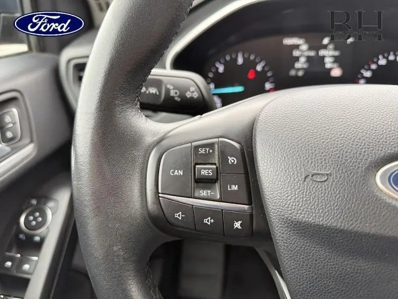 Gros plan sur le volant cuir multifonction noir de la Ford Focus SW 2019 avec commandes de régulateur et limitation de vitesse.