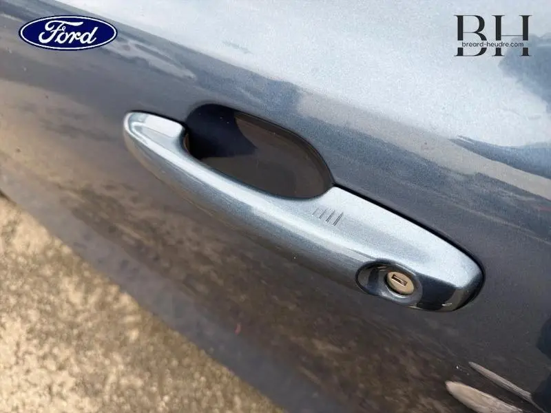 Gros plan sur la poignée de porte côté gauche en Bleu Azur métallisé de la Ford Focus SW 2019.