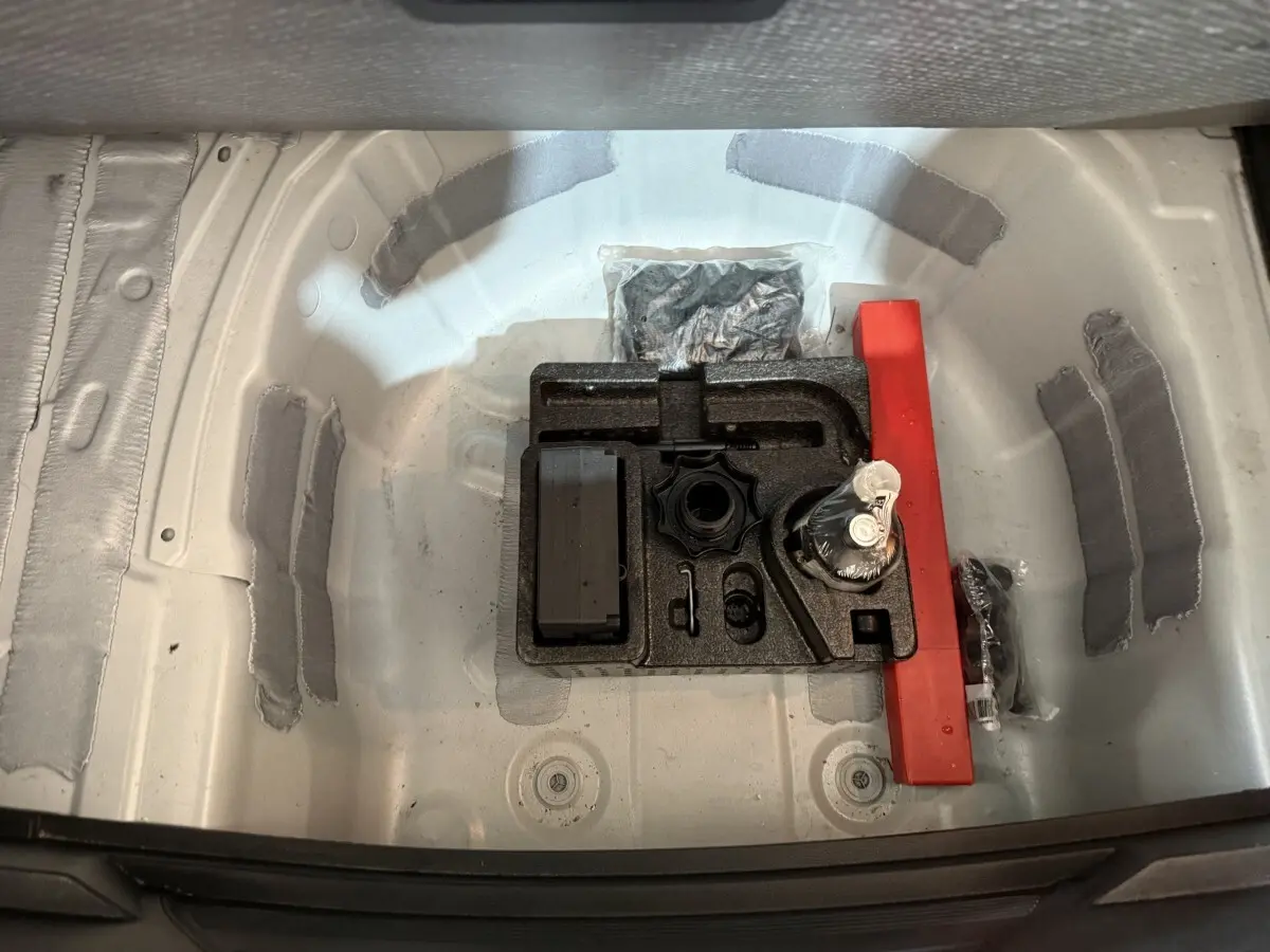 Vue plongeante sur le coffre blanc de la SEAT Ibiza 2024, montrant le rangement d’outils et accessoires d’origine.