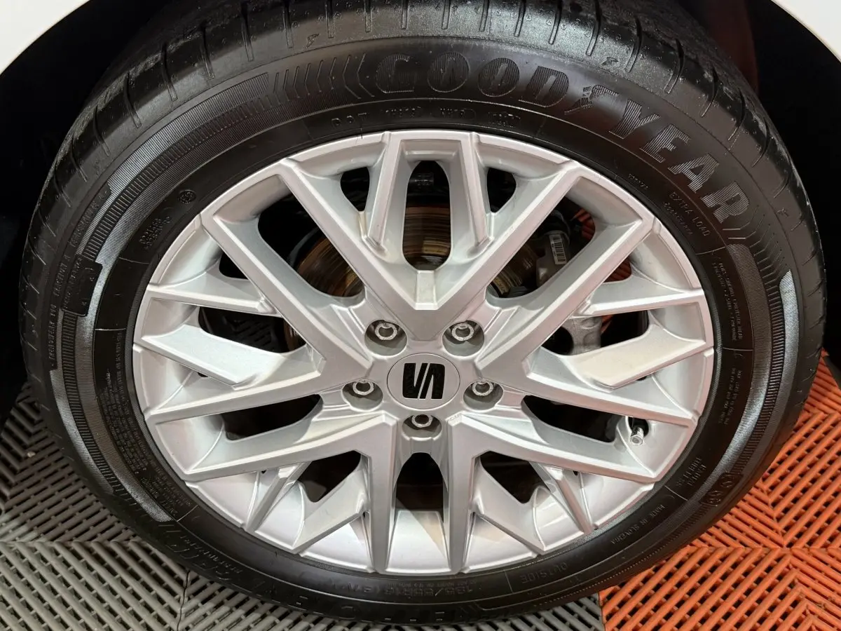 Gros plan sur la jante alu argentée avec logo SEAT, montée sur un pneu Goodyear noir.