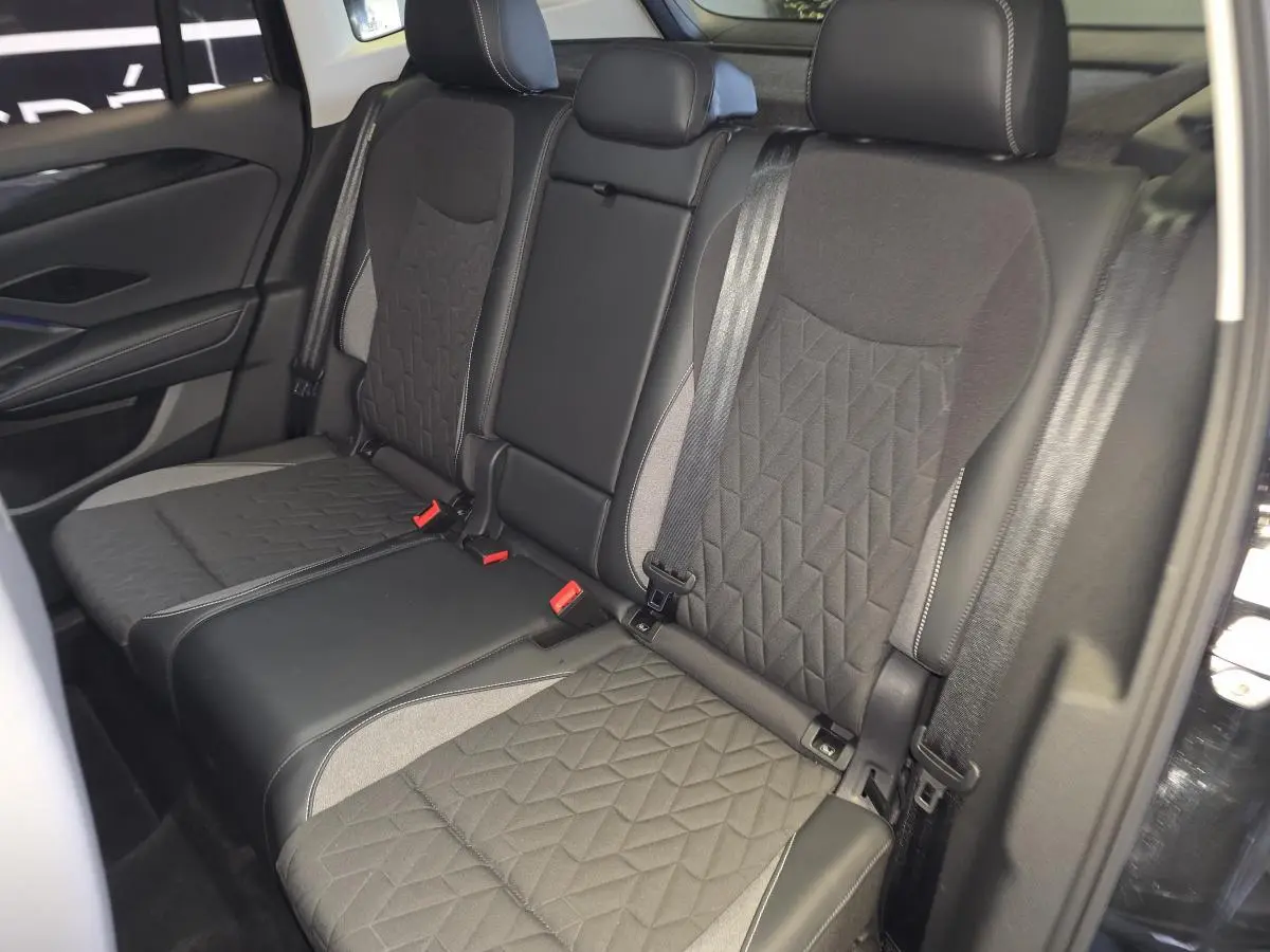 Vue intérieure côté droit des sièges arrière noirs avec motifs géométriques du Volkswagen Tiguan 2025.