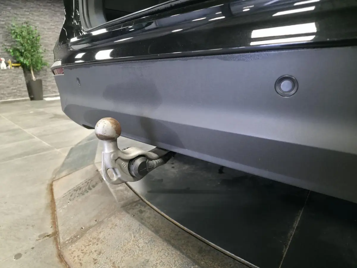 Vue rapprochée du crochet d'attelage escamotable à l'arrière d'un Volkswagen Tiguan noir 2025.