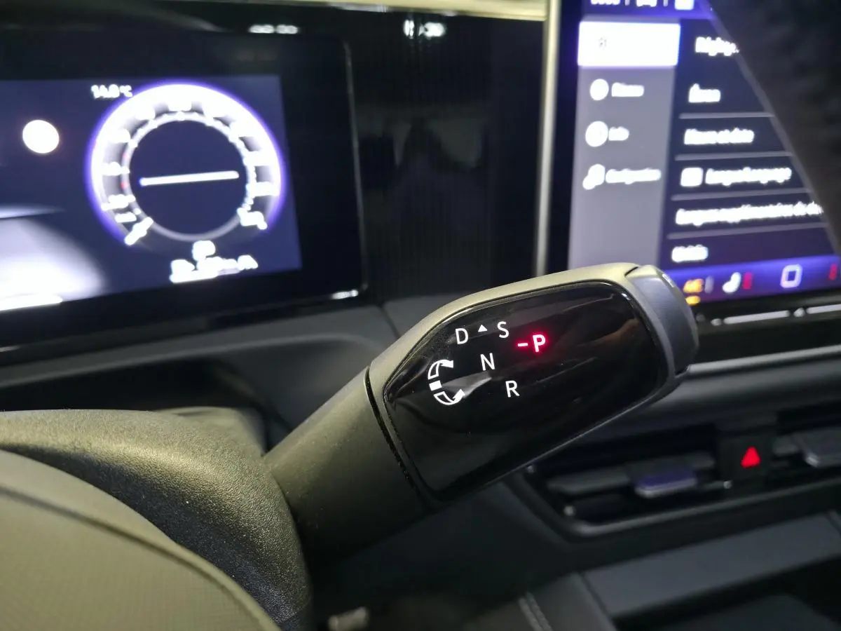 Le levier de vitesses automatique noir du Volkswagen Tiguan 2025, avec tableau de bord numérique en arrière-plan.