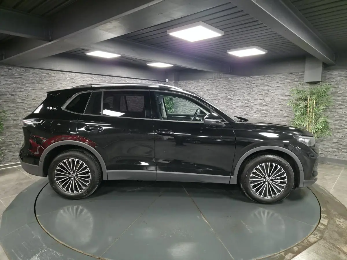 Volkswagen Tiguan noir en vue profil droit, avec jantes alliage 18 pouces et toit ouvrant panoramique.