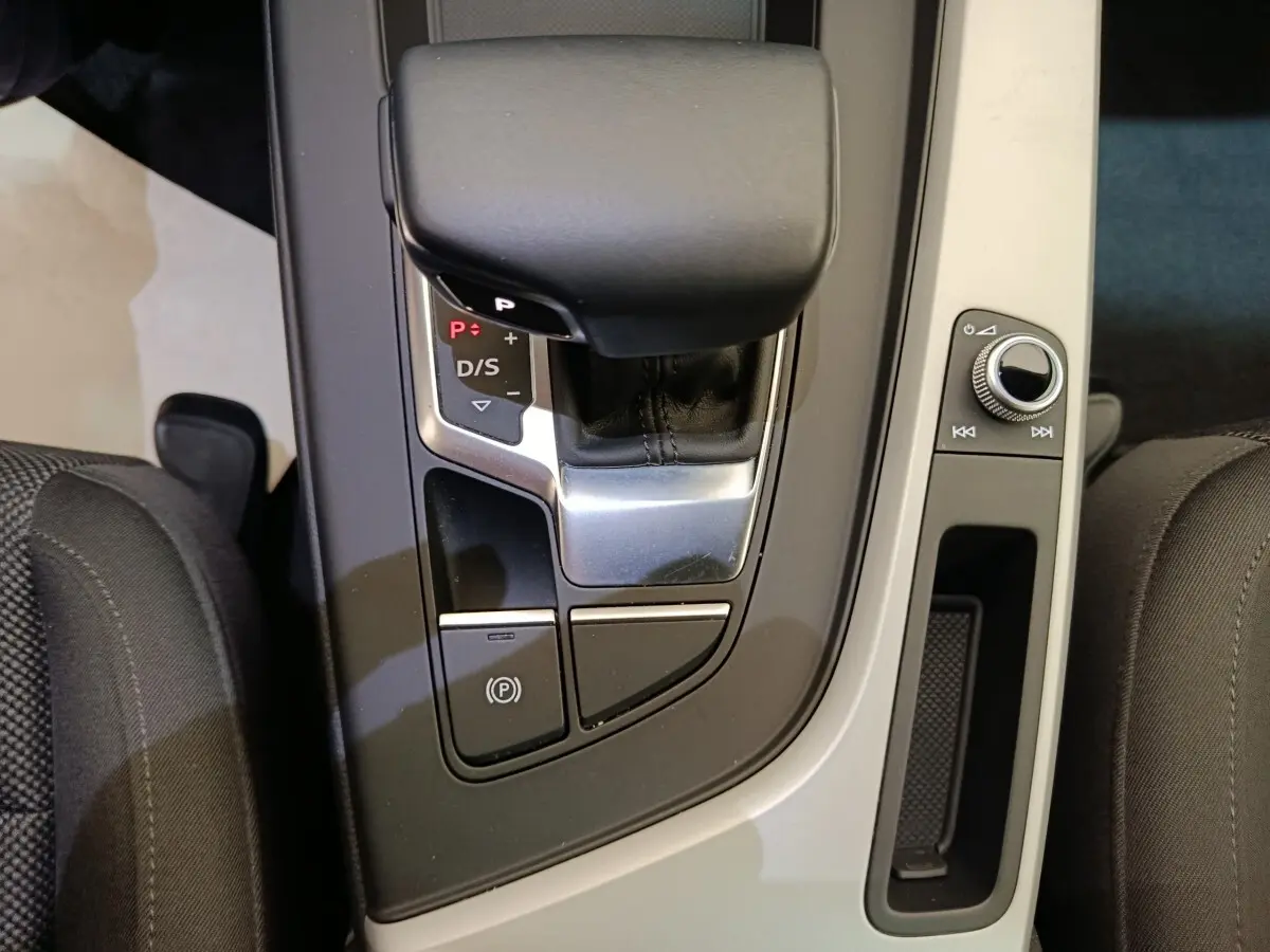 Vue rapprochée de la console centrale noire et grise de l’Audi A4 35 TFSI, avec levier de vitesse automatique et commandes.
