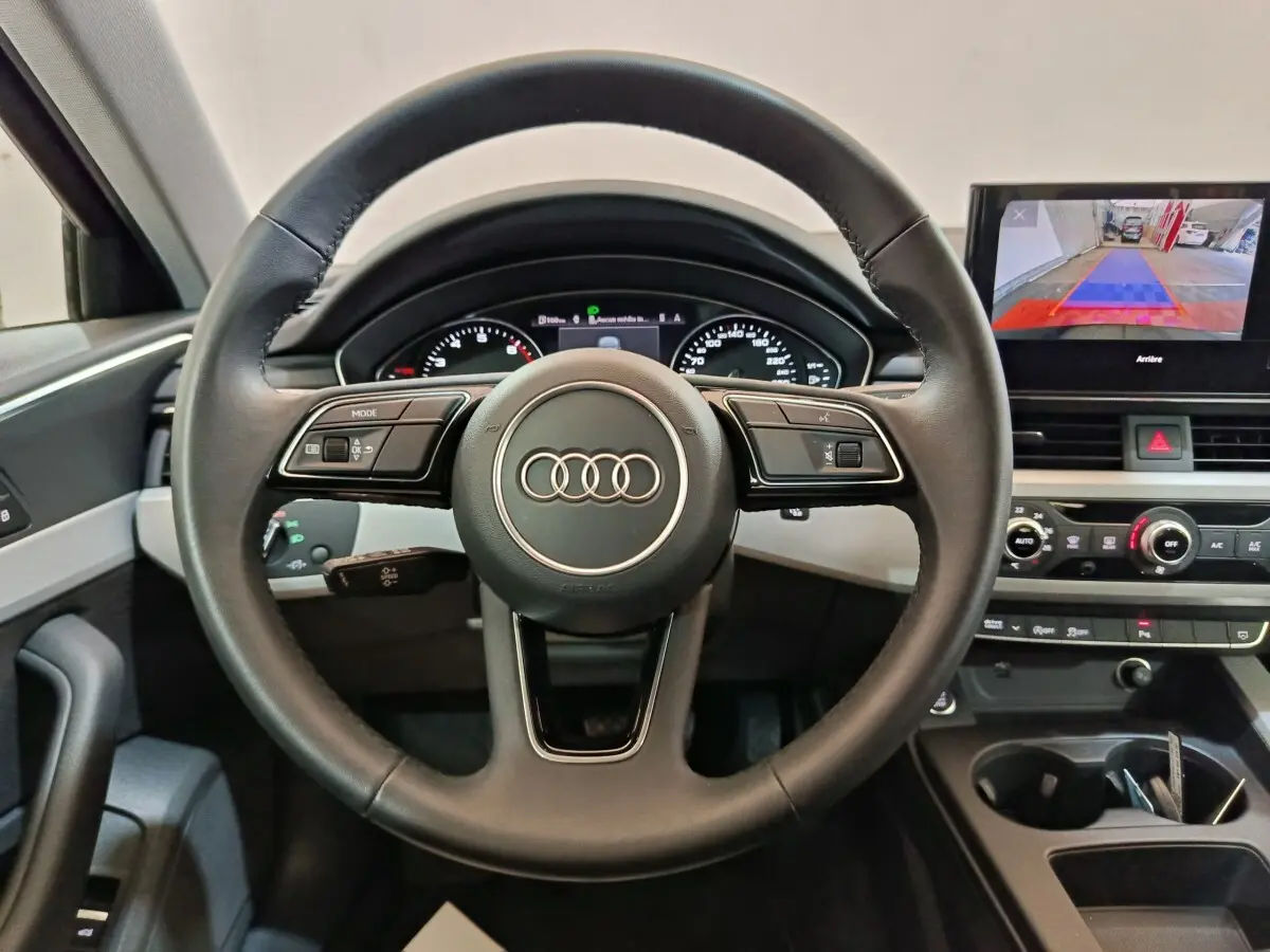 Vue intérieure frontale du volant cuir noir Audi A4 35 TFSI avec tableau de bord digital et écran central tactile.