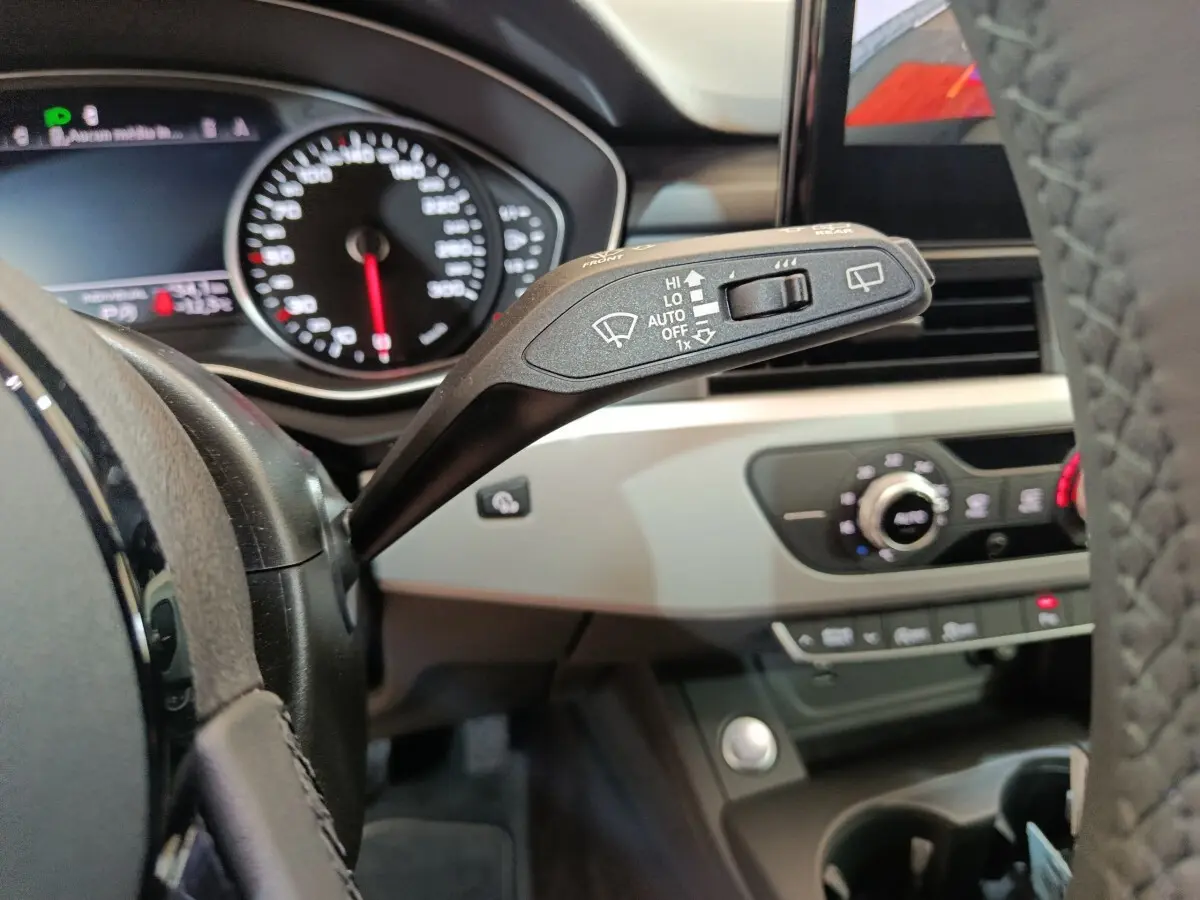 Gros plan sur la manette d’essuie-glace côté gauche du tableau de bord beige et noir d’une Audi A4 35 TFSI 2024.