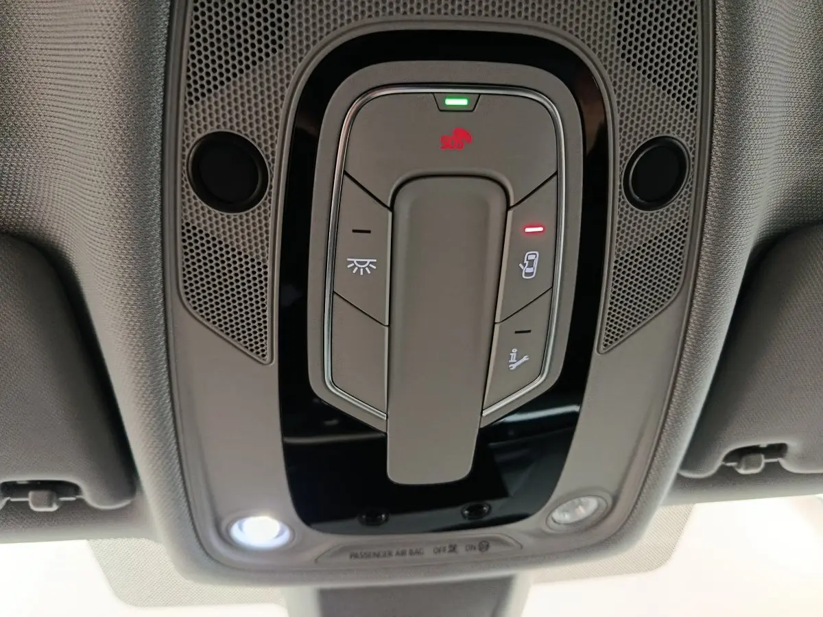 Vue en gros plan du panneau de commandes au plafond de l'Audi A4 35 TFSI Business Line noire, avec éclairage et bouton SOS.