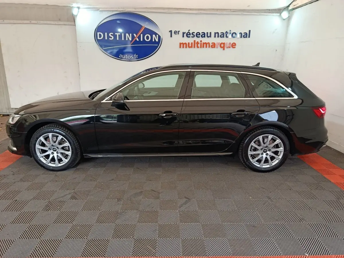 Profil droit d'une Audi A4 35 TFSI Business Line noire, break essence hybride, roues alliage et toit ouvrant visible.