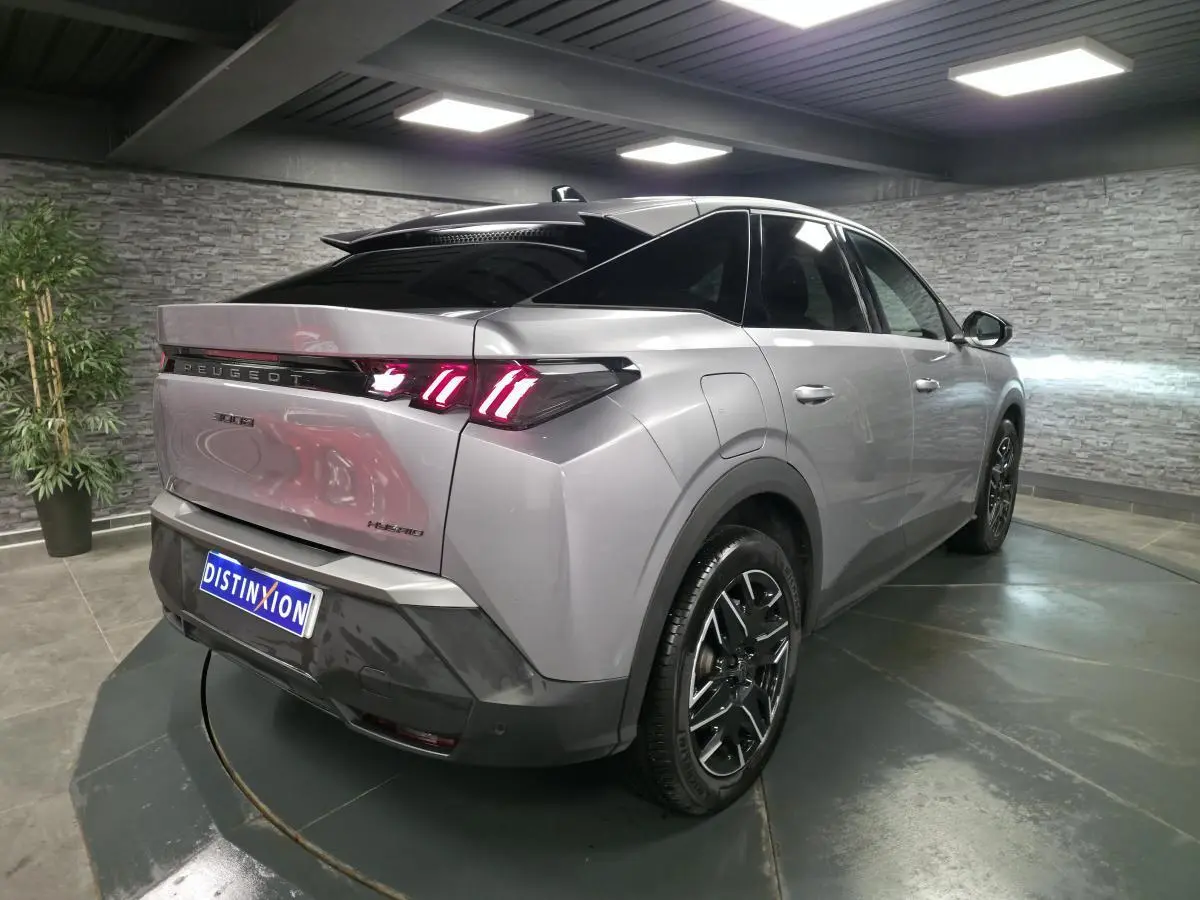 Vue 3/4 arrière droite du Peugeot 3008 hybride gris métallisé avec feux arrière LED à 3 griffes et jantes alliage noires.