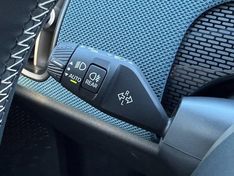Gros plan sur la commande des feux et clignotants du MINI Countryman 2024, avec finition intérieure bleu texturé.