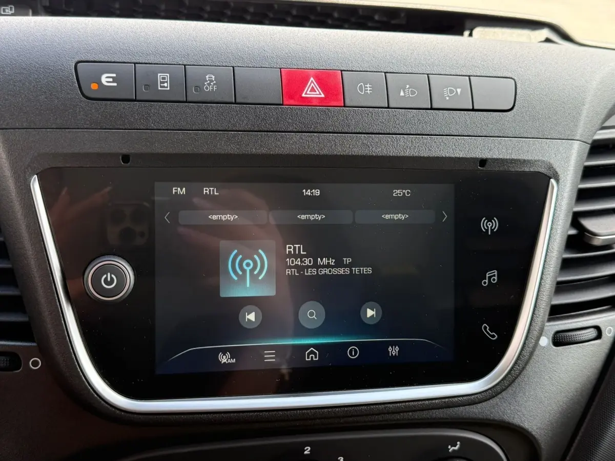 Écran tactile central du tableau de bord de l’Iveco Daily 2026, affichant la radio RTL, entouré de boutons de contrôle.
