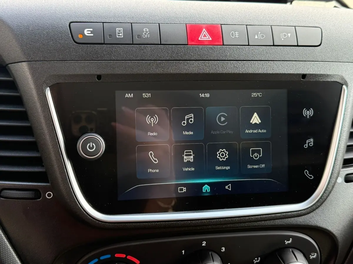 Écran tactile central et rangée de boutons de commande sur le tableau de bord du Iveco Daily blanc 2026.