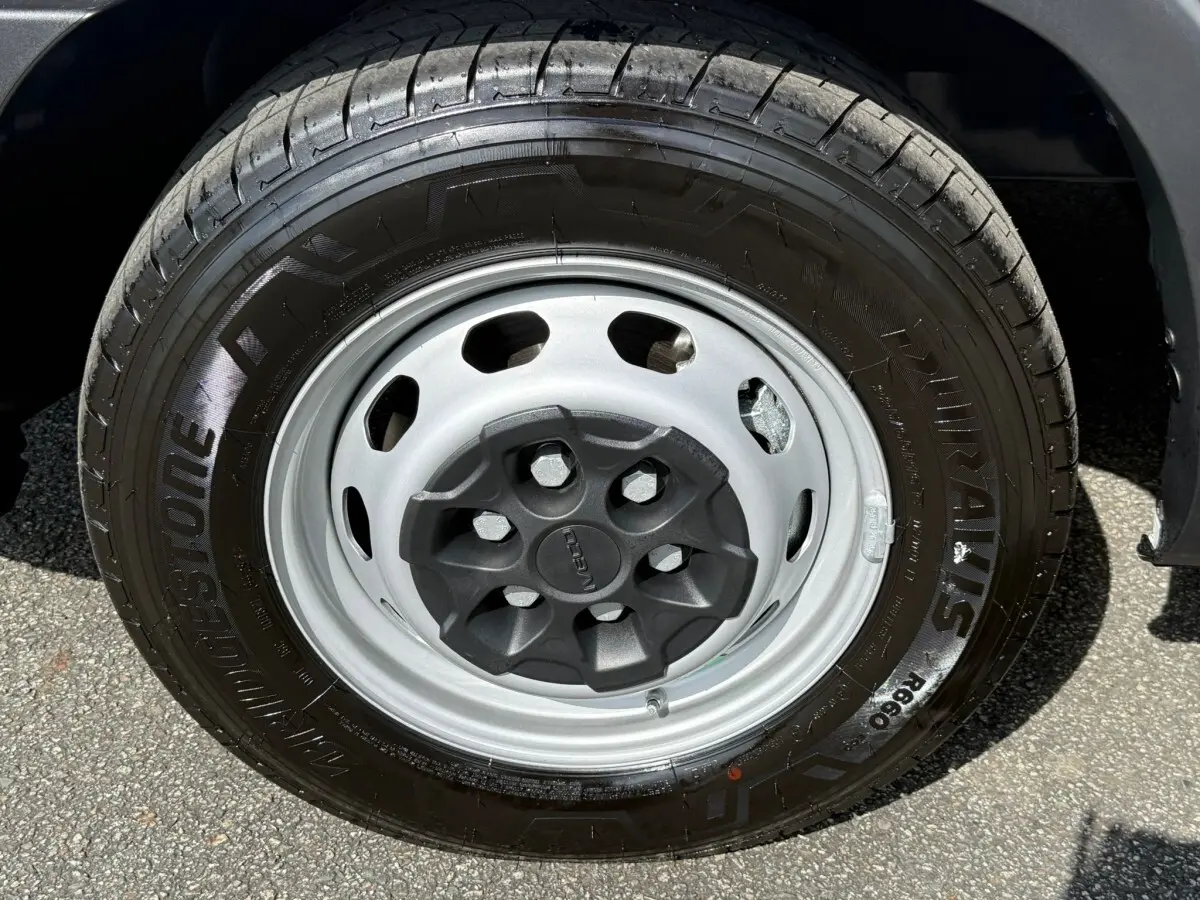 Gros plan sur la roue avant droite blanche d’un Iveco Daily 2026 avec pneu Bridgestone noir.