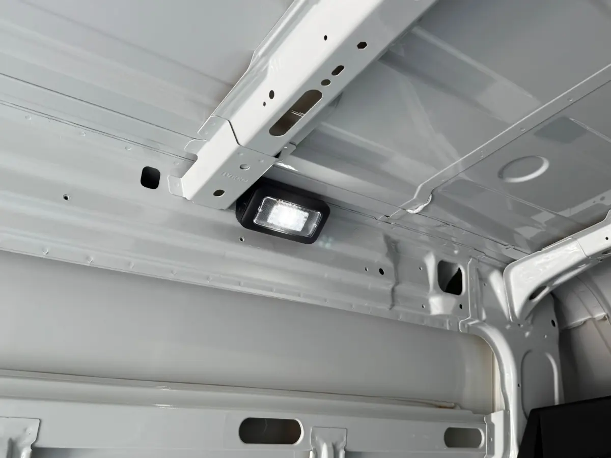 Vue intérieure du plafond blanc du fourgon Iveco Daily 2026, mettant en valeur une lampe LED intégrée.
