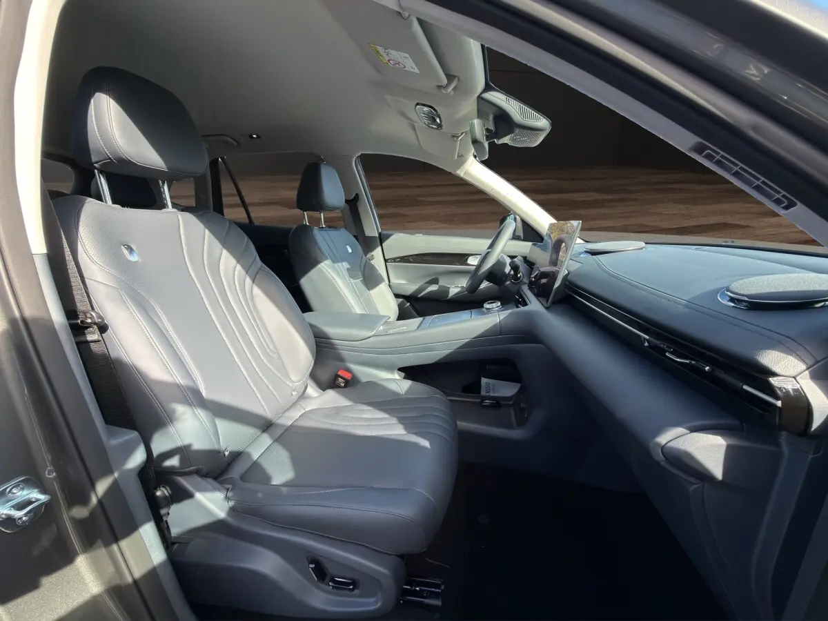 Vue intérieure côté gauche du Geely E5 2026 gris foncé, avec sièges en cuir et tableau de bord moderne.