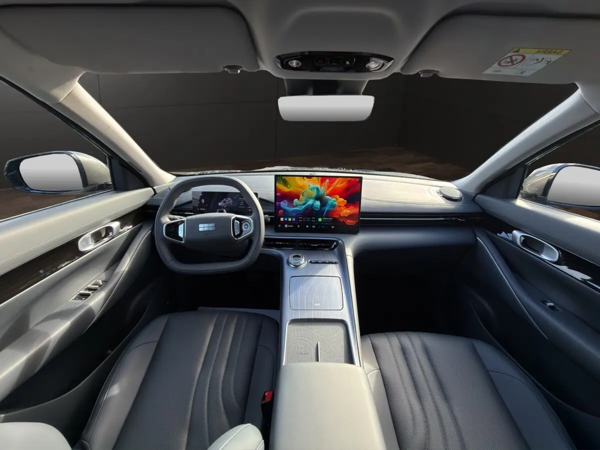 Vue intérieure avant du Geely E5 gris foncé 2026, avec tableau de bord moderne et écran tactile central coloré.