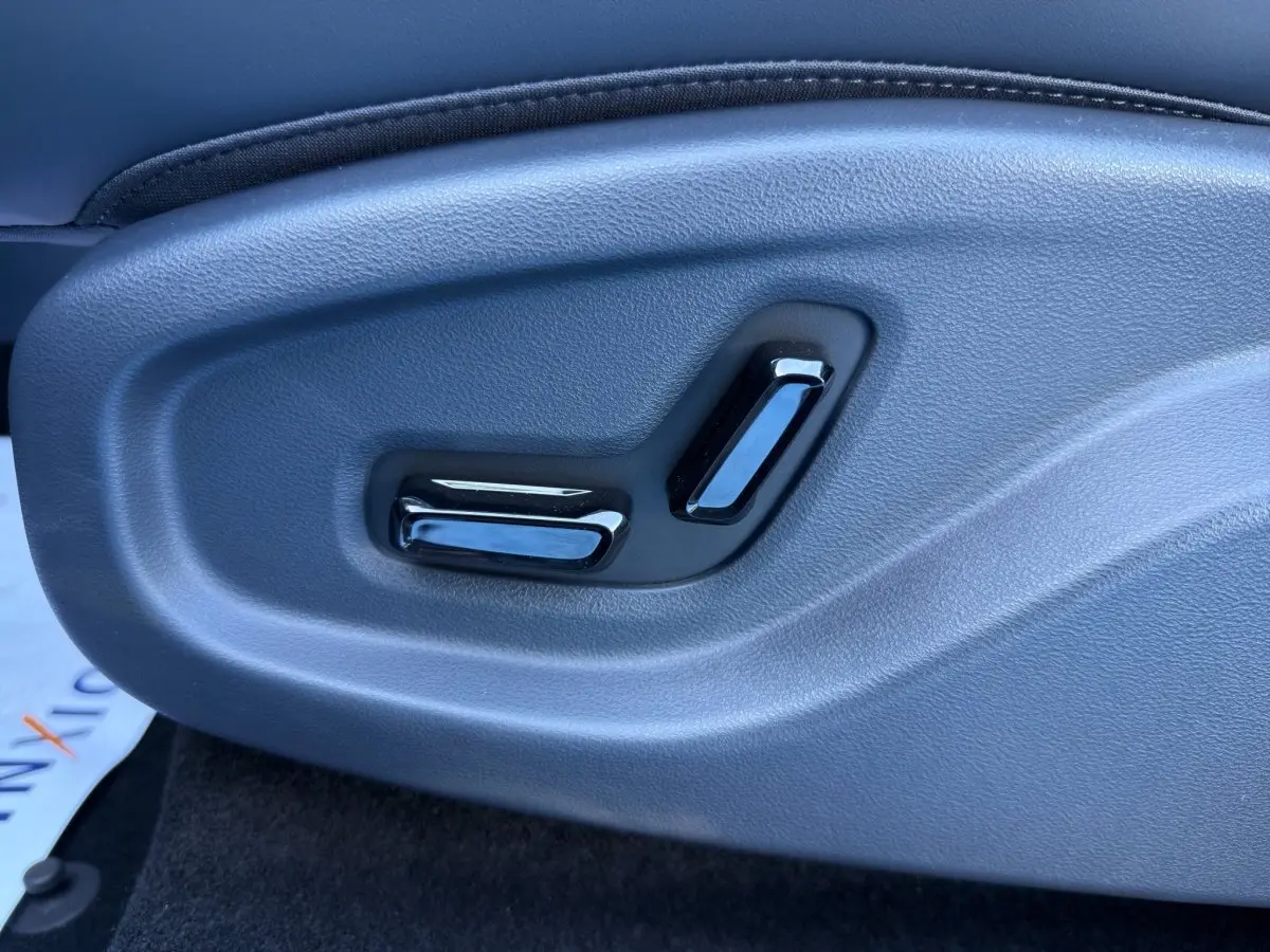 Détail des commandes de réglage électrique du siège côté conducteur dans un GEELY E5 gris foncé 2026.