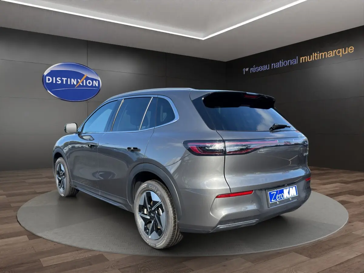 Vue 3/4 arrière droite du SUV électrique GEELY E5 gris foncé, avec feux arrière connectés et jantes modernes.