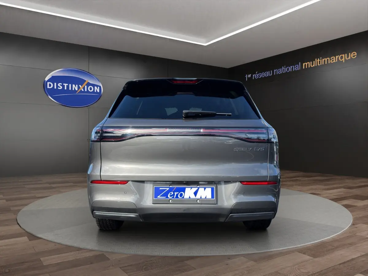 Vue arrière d’un SUV électrique Geely E5 gris foncé, avec feux arrière étirés et plaque d’immatriculation Zero KM.