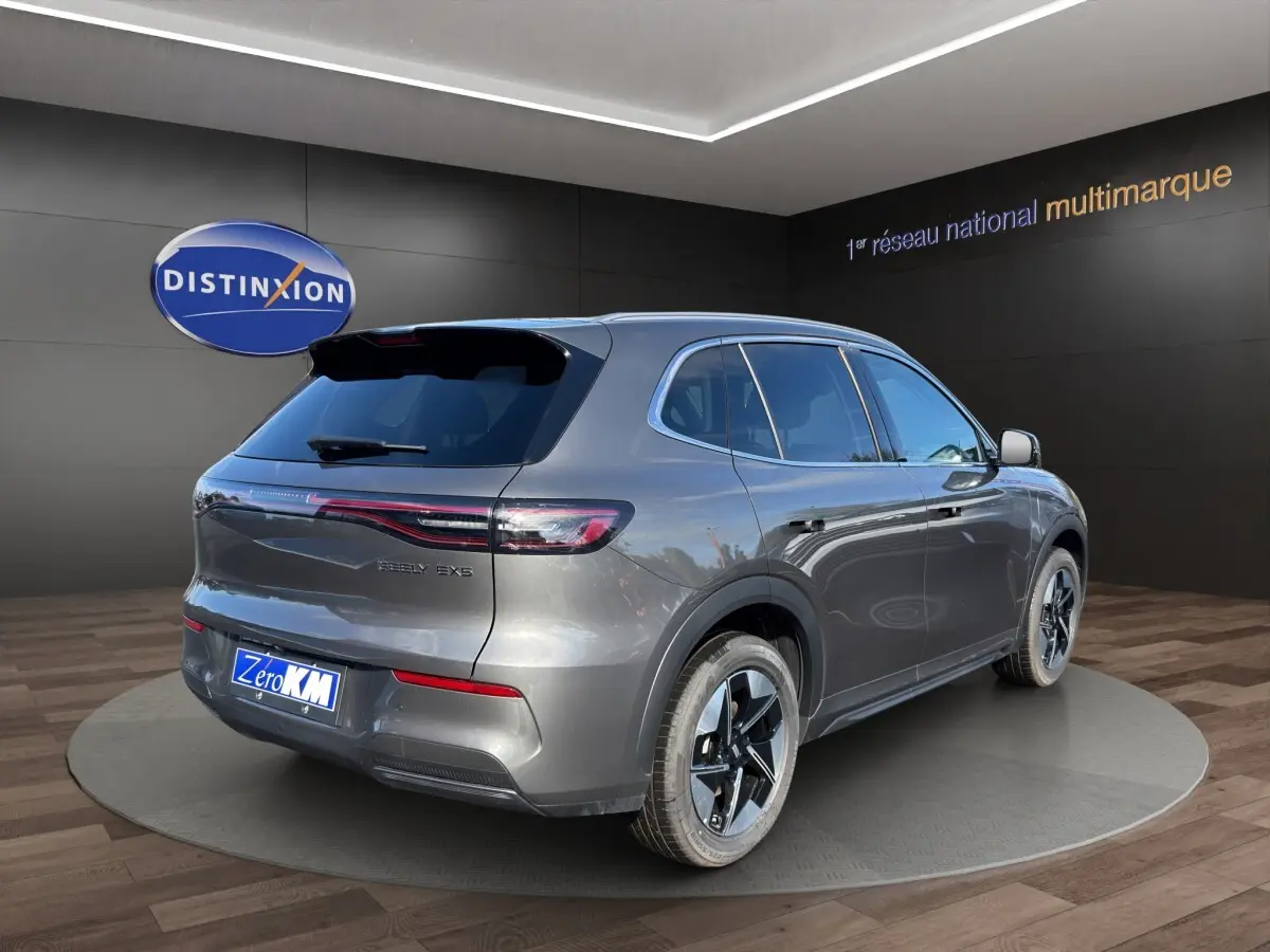 Vue 3/4 arrière droite du SUV électrique Geely E5 gris foncé, avec feux arrière fins et jantes modernes.