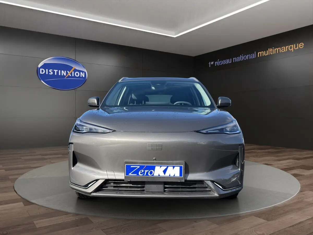 Vue avant du SUV électrique GEELY E5 gris foncé 2026, avec phares fins et calandre épurée en showroom.