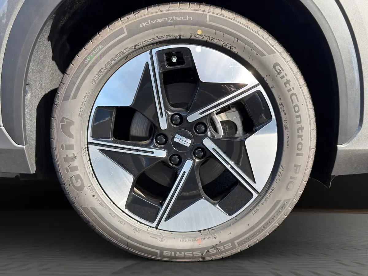 Gros plan sur la roue avant droite du Geely E5 gris foncé 2026 avec jante noire et argentée au design moderne.