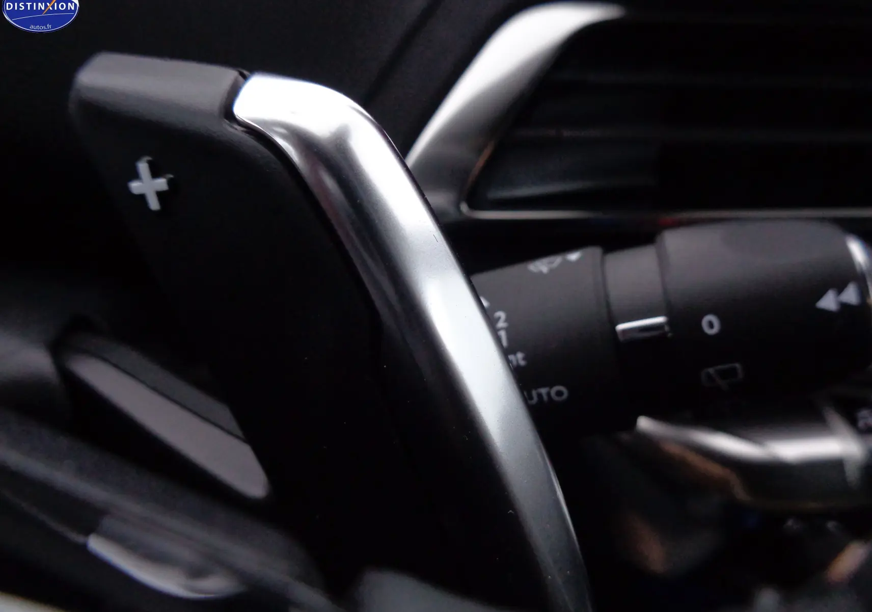 Gros plan sur la palette de changement de vitesse + côté droit du Peugeot 3008 gris platinium, avec commandes au volant visibles.