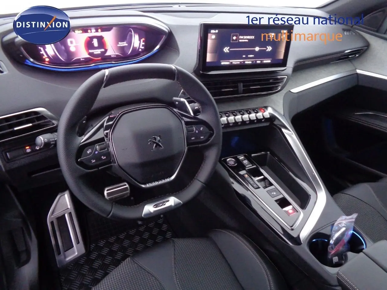 Intérieur de Peugeot 3008 GT 2023 en vue cockpit, volant compact, écran tactile et console centrale moderne noire.