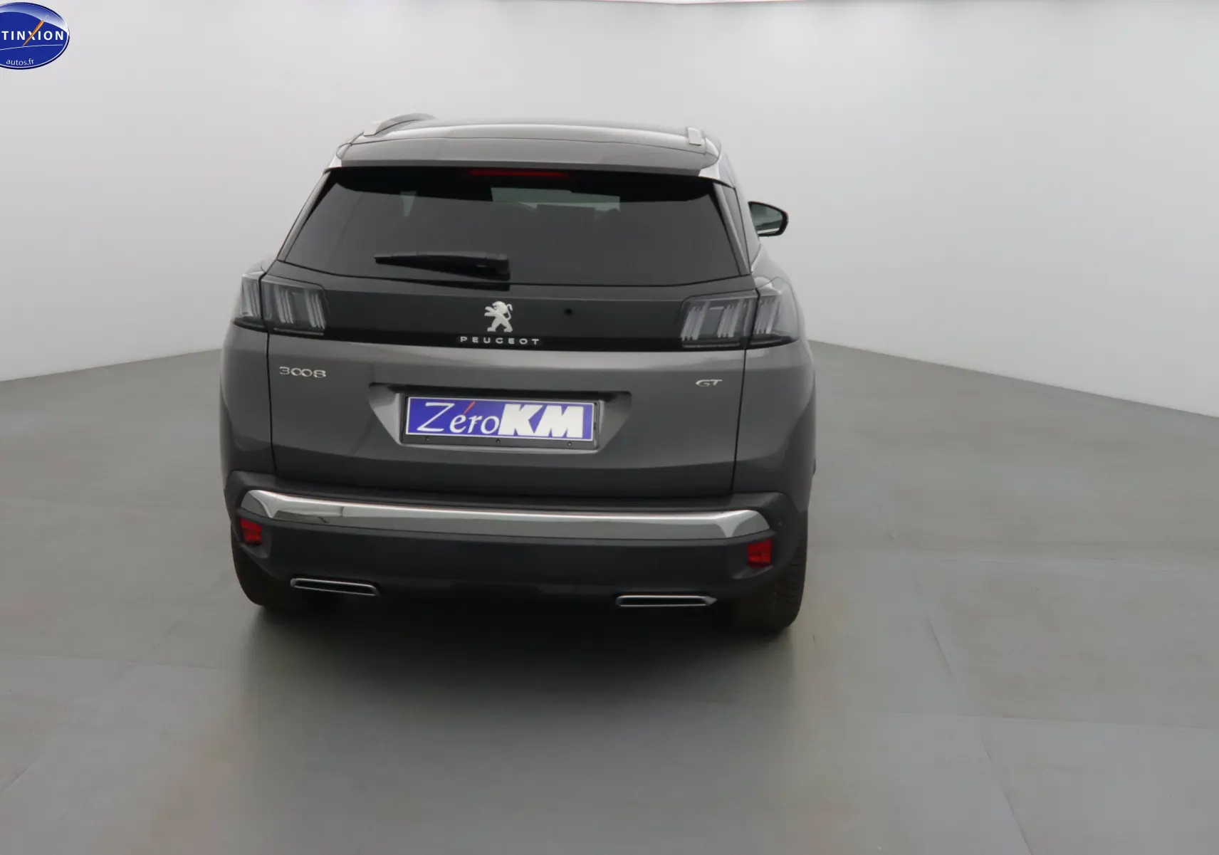 Vue arrière d'un Peugeot 3008 GT gris platinium métal avec feux arrière LED et double sortie d'échappement intégrée.