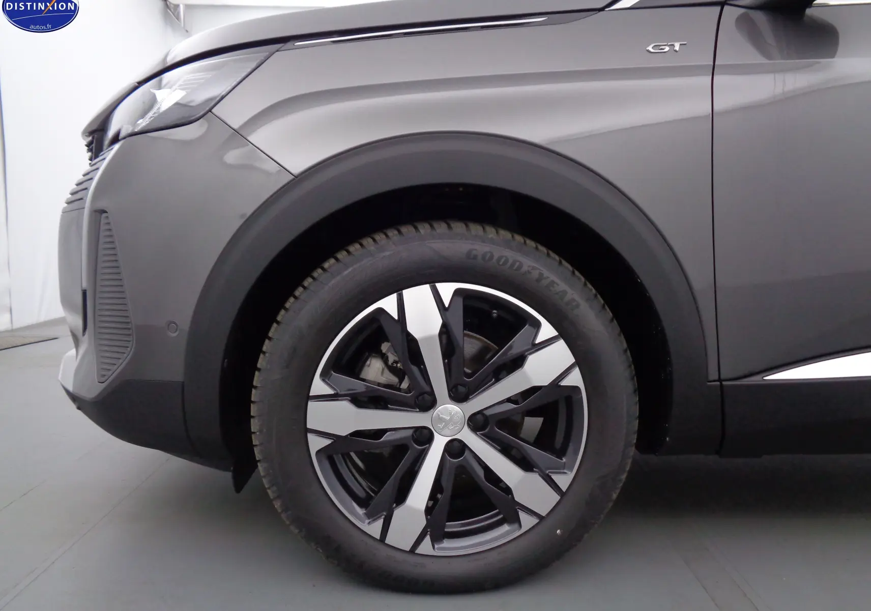 Gros plan sur la roue avant gauche et l'aile gris platinium du Peugeot 3008 GT avec logo GT visible.