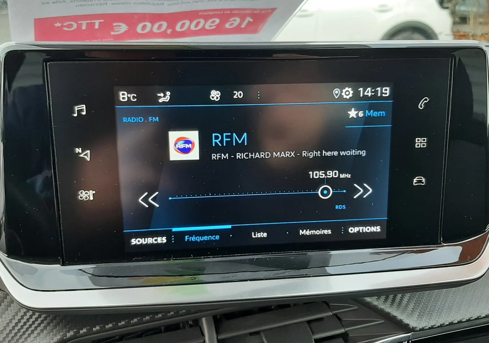 Écran tactile central affichant la radio RFM dans l'habitacle noir d'un Peugeot 2008 gris 2021.