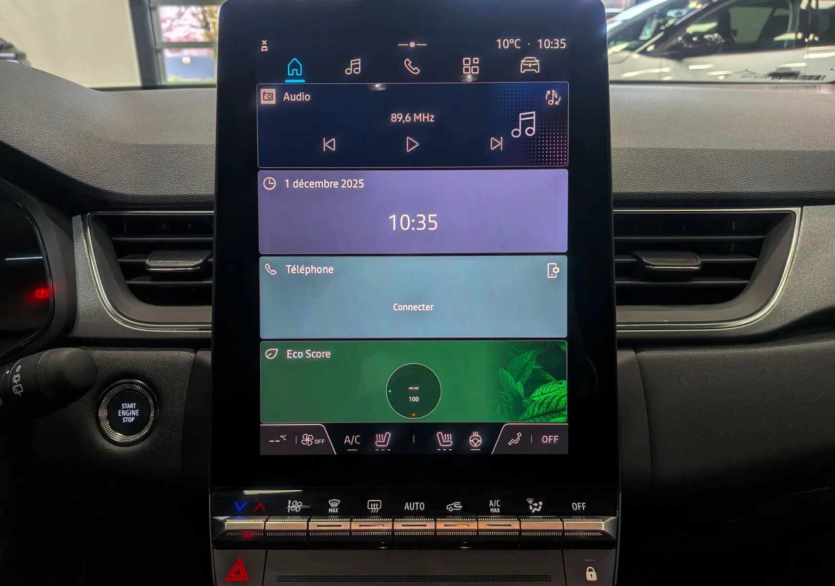 Écran tactile central du tableau de bord du Renault Captur 2025, affichant radio, téléphone et score éco.