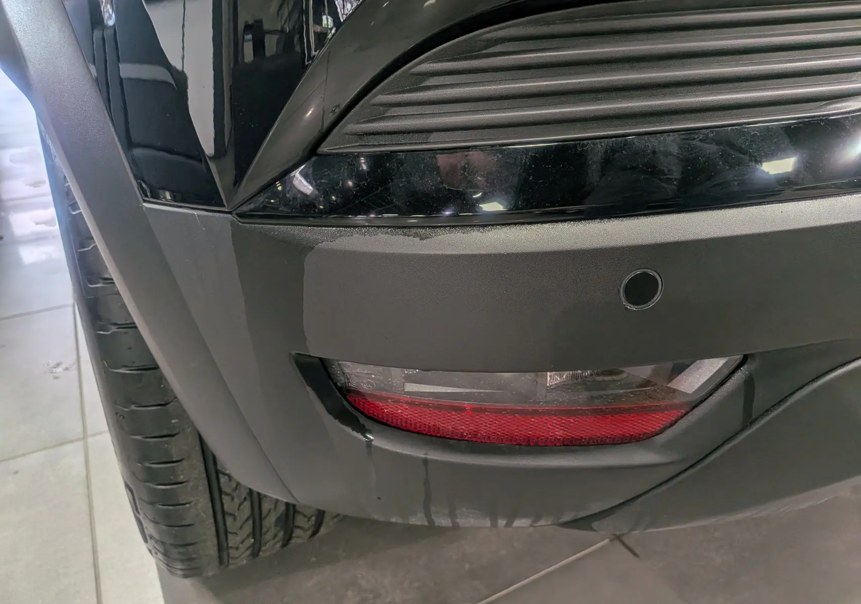 Gros plan sur le feu arrière droit noir du Renault Captur Mild Hybrid 160 CH EDC TECHNO 2025 avec capteur de recul.