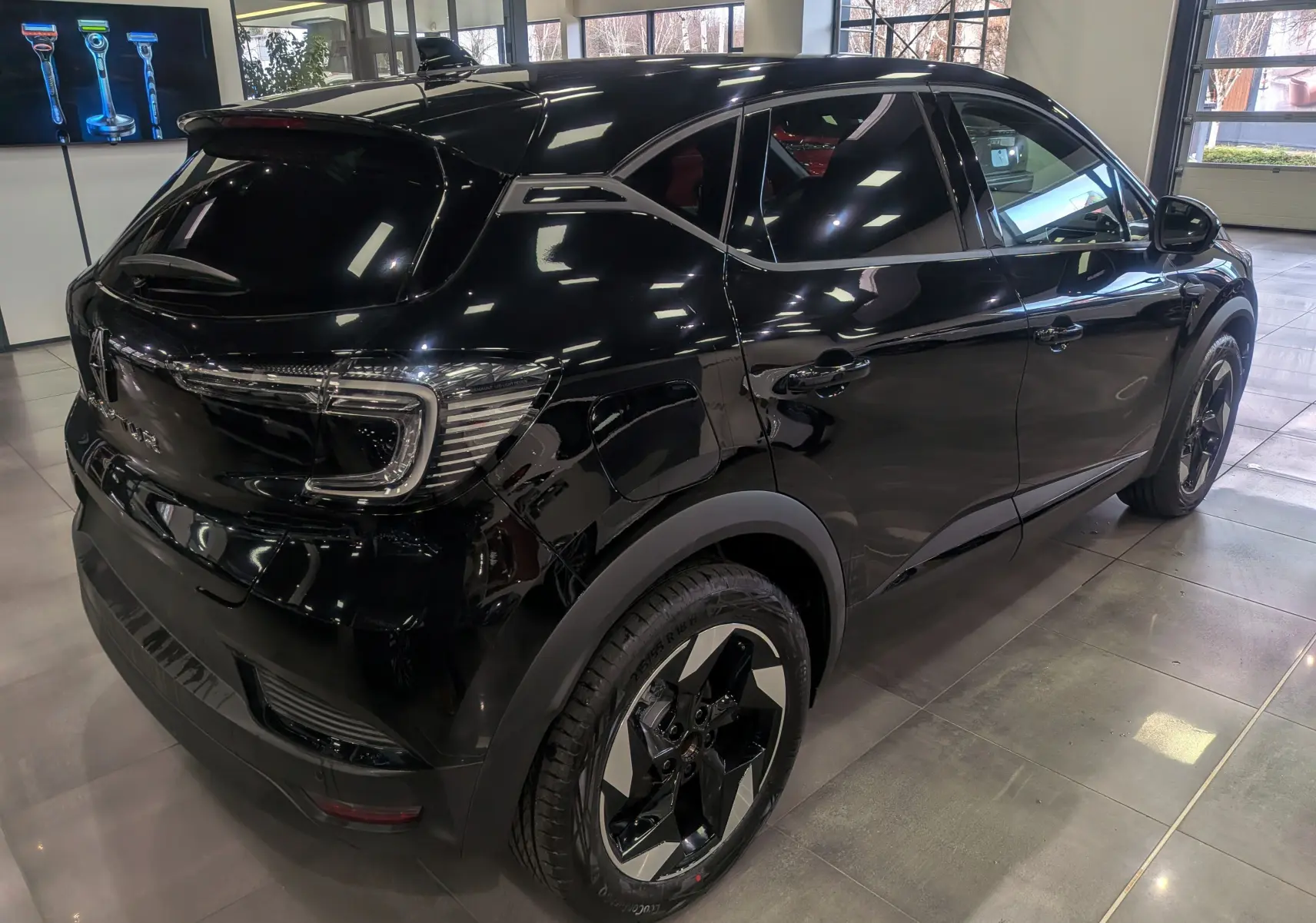 Renault Captur noir en 3/4 arrière droit, mettant en valeur ses feux LED et jantes biton modernes.