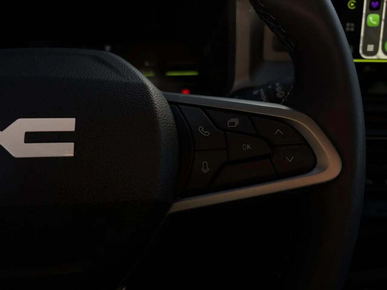 Gros plan sur les commandes multifonctions côté droit du volant du Dacia Duster 2026, intérieur noir.