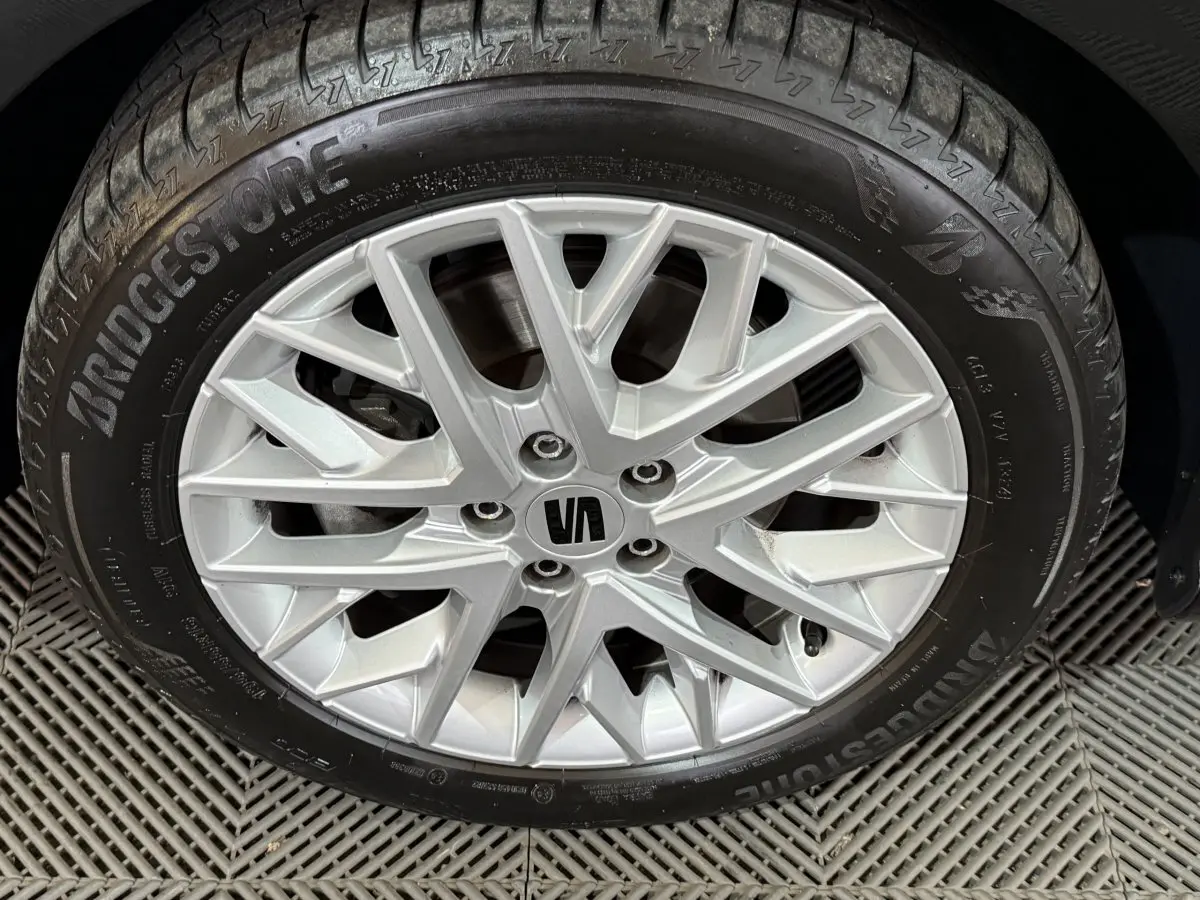 Gros plan sur la jante alliage argentée et pneu Bridgestone du SEAT Ibiza noir, détail distinctif de la roue.