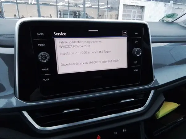 Écran tactile central du tableau de bord du Volkswagen T-Roc 2025, affichant le menu service en intérieur noir et gris.