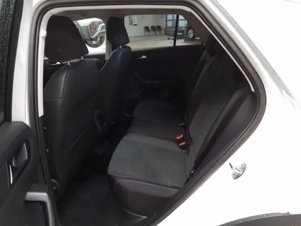 Vue intérieure côté gauche sur les sièges arrière noirs du Volkswagen T-Roc blanc toit noir 2025.