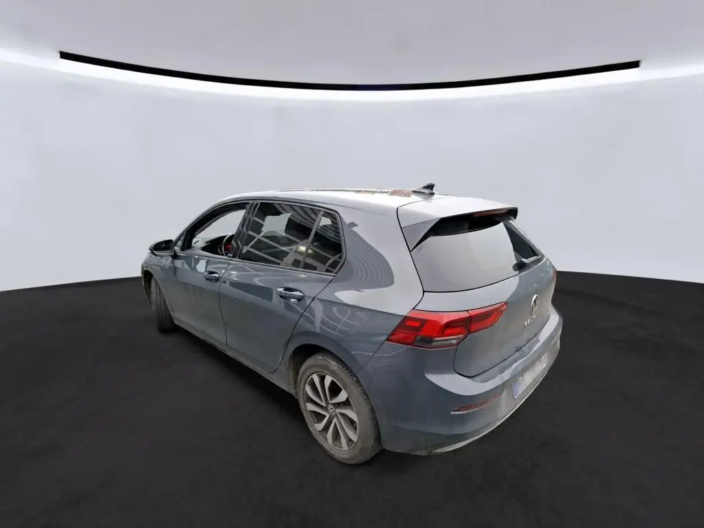 Volkswagen Golf gris vue 3/4 arrière droit, compacte cinq portes avec feux arrière LED et jantes alliage.
