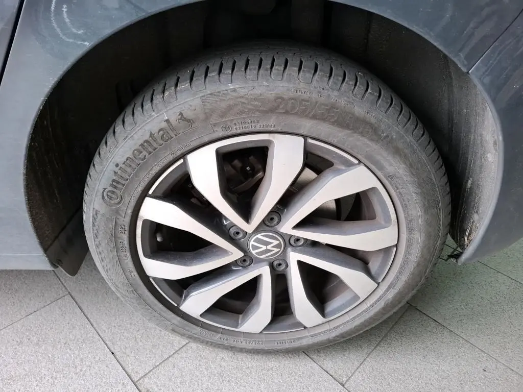 Gros plan sur la roue avant gauche d'une Volkswagen Golf gris 2022 avec jante alliage et pneu Continental.