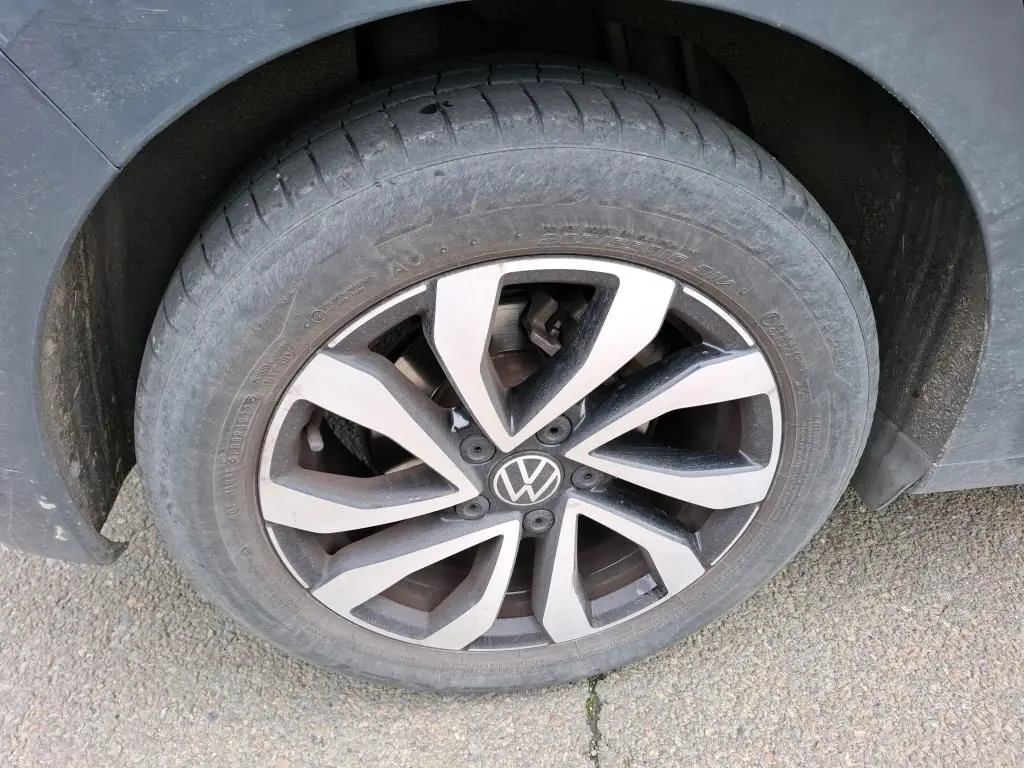 Gros plan sur la roue avant gauche de la Volkswagen Golf gris 1.5 eTSI 130 DSG7 avec jante alliage distinctive.