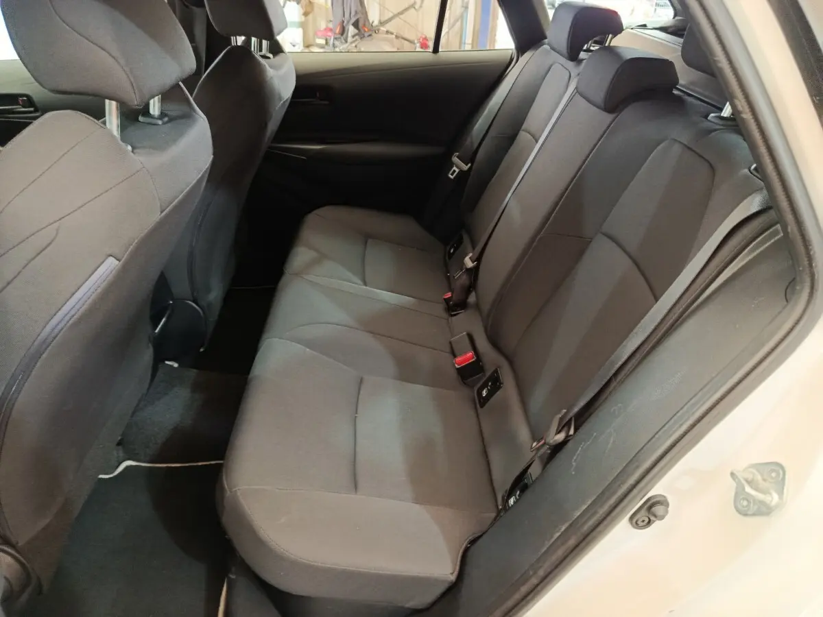 Vue intérieure côté droit montrant la banquette arrière noire de la Toyota Corolla Hybride 122h Active blanche de 2020.