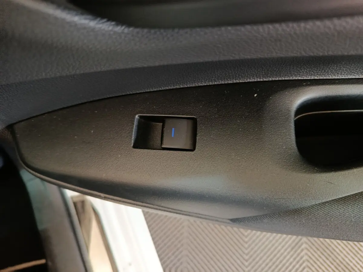 Gros plan sur le bouton de réglage électrique du siège côté conducteur dans une Toyota Corolla Hybride blanche de 2020.