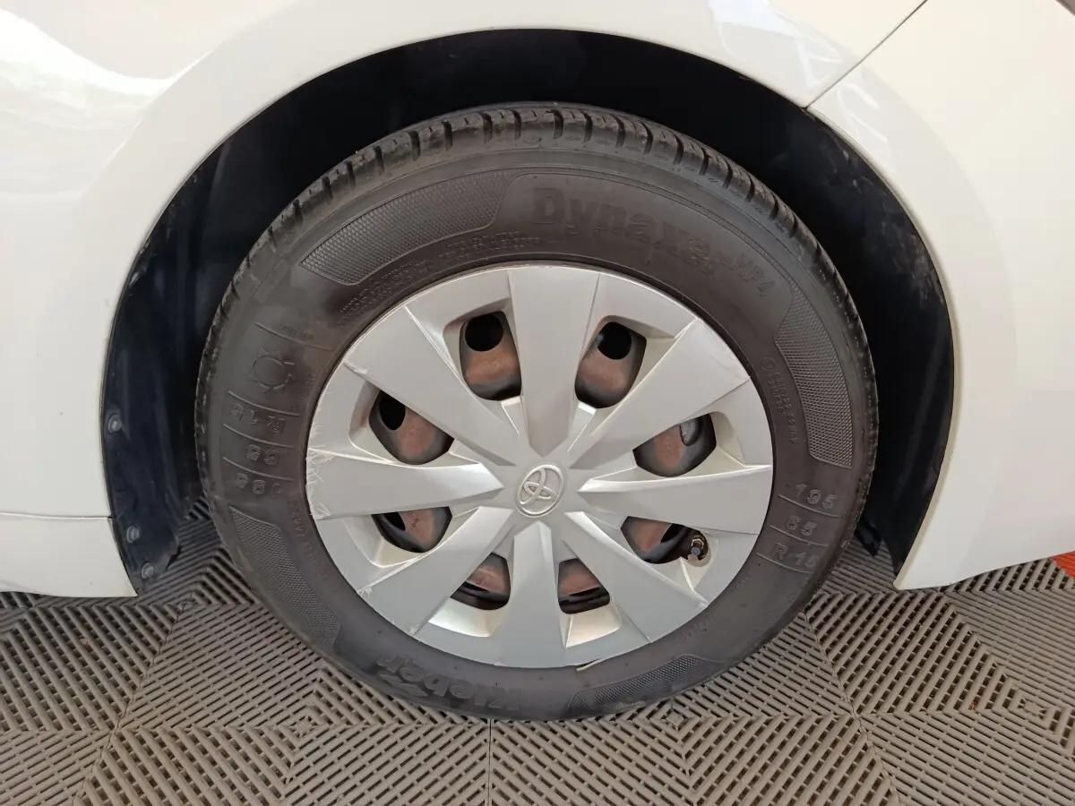 Gros plan sur la roue arrière droite blanche d'une Toyota Corolla Hybride 122h Active avec enjoliveur gris.