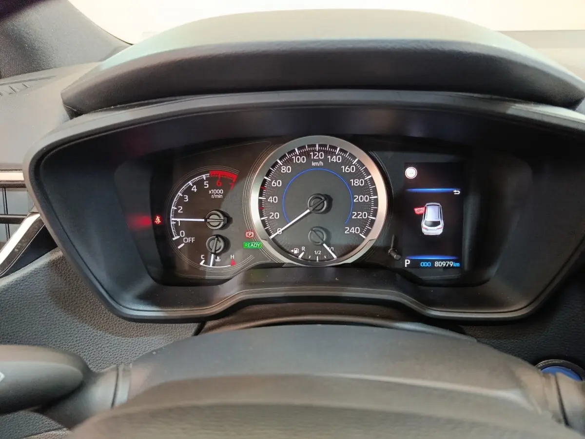 Vue rapprochée du tableau de bord de la Toyota Corolla Hybride 122h, affichage digital avec compteur et indicateurs.