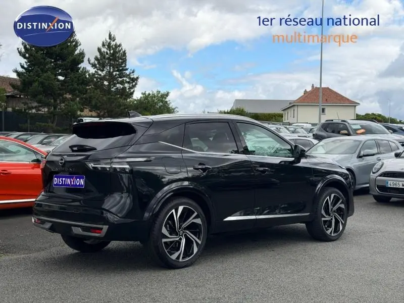 Nissan Qashqai 2024 noir Kuro métallisé vu en 3/4 arrière droit sur parking multimarque.