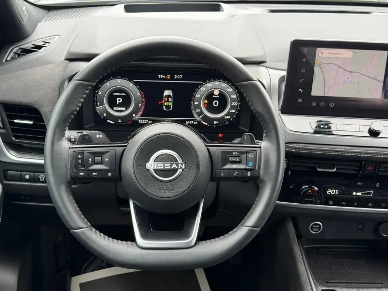 Vue intérieure centrée sur le volant cuir noir du Nissan Qashqai 2024 avec tableau de bord numérique et écran tactile GPS.