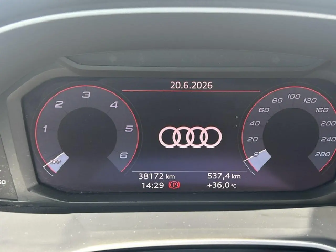 Combiné d'instruments numérique Audi Q3 blanc, affichant logo Audi, vitesse et compte-tours en rouge, vue de face.