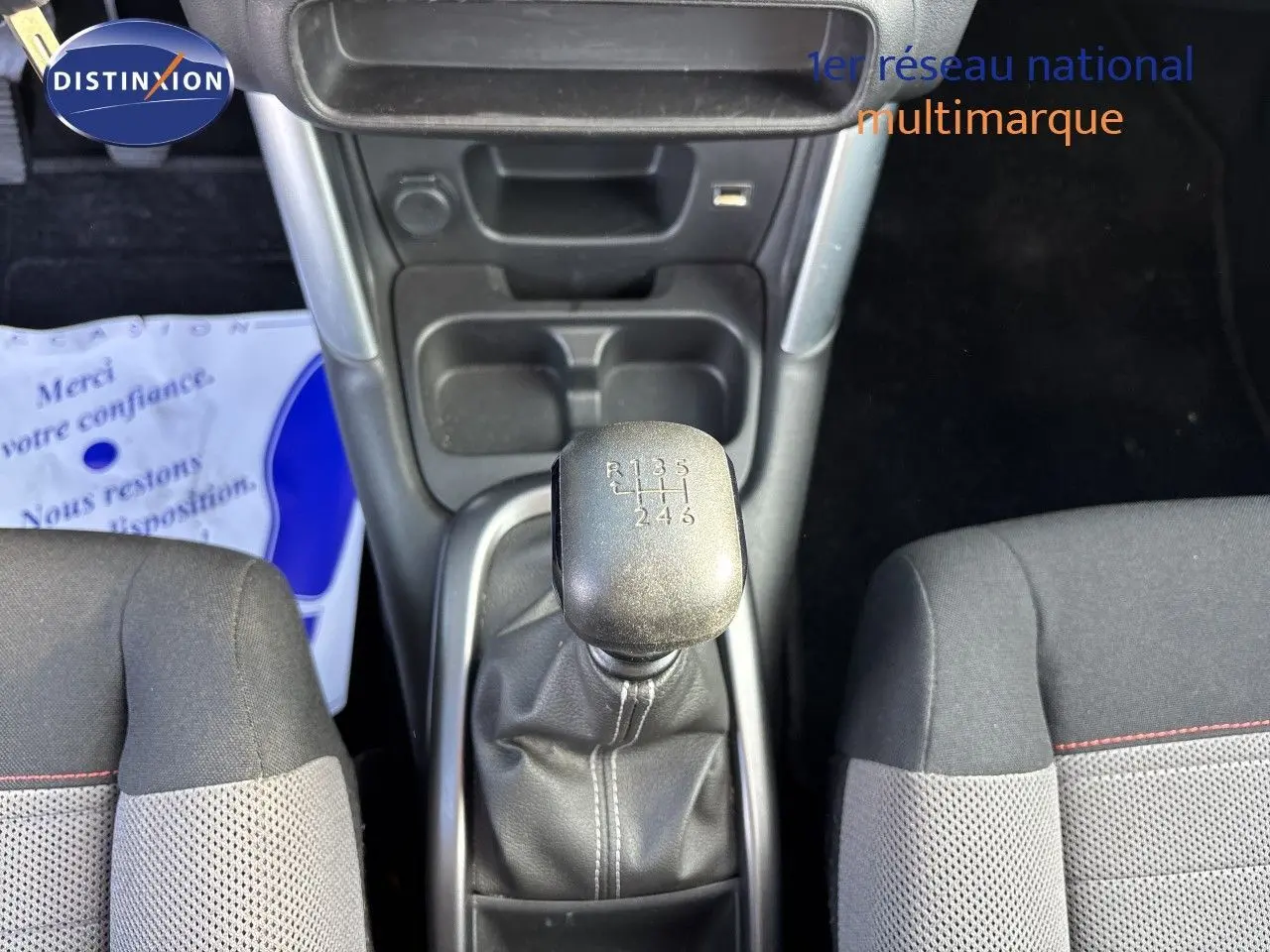 Vue plongeante sur la boîte manuelle et les sièges tissu noir avec surpiqûres rouges du Citroën C3 Aircross noir Perla Metal.
